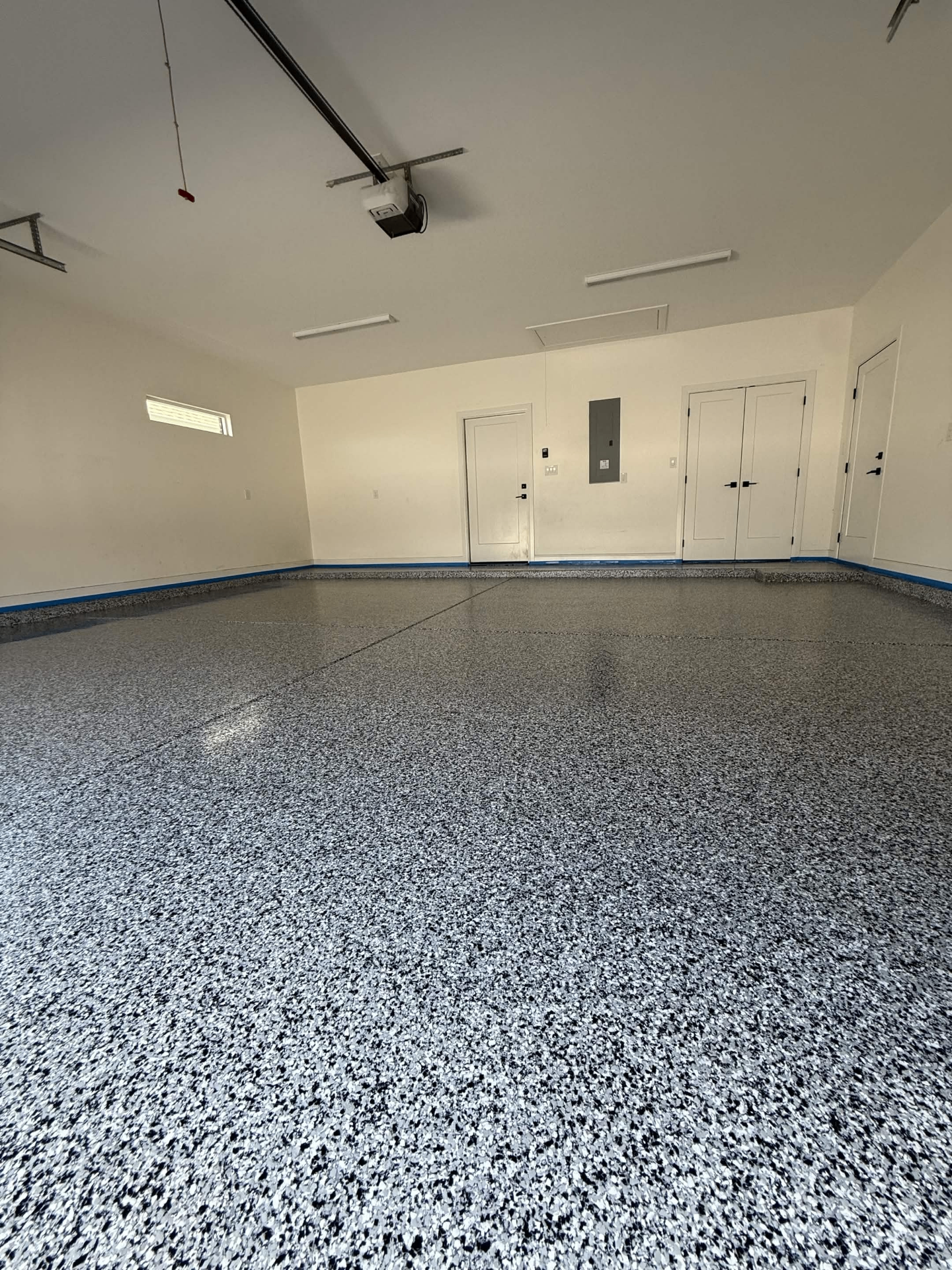 Empty garage showing a completed decorative flake floor